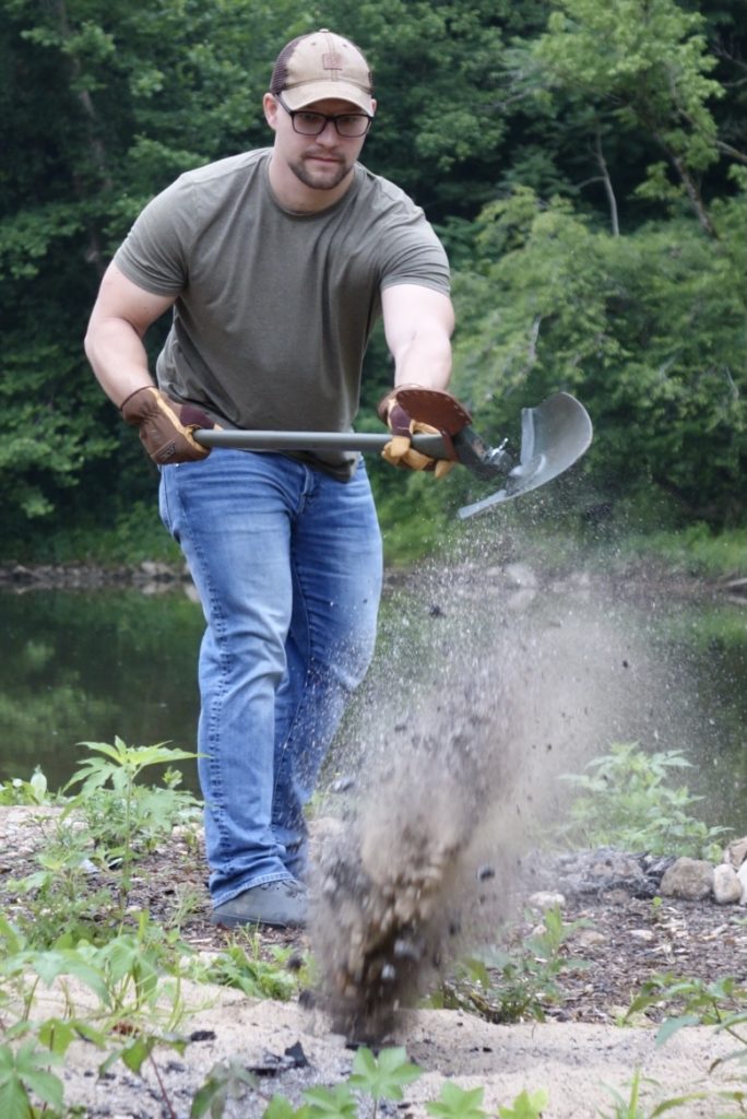 A man shoveling out a fire pit.