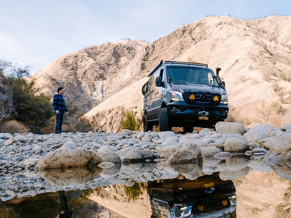 Field Van in the backcountry near a water feature.