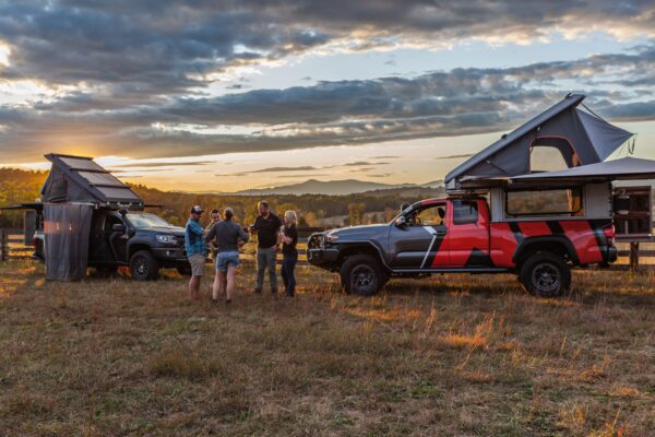 Attendees in camp with the sunset behind them.