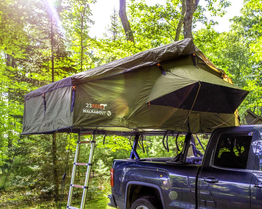 Roof top tent on a bedrack with trees in the background.