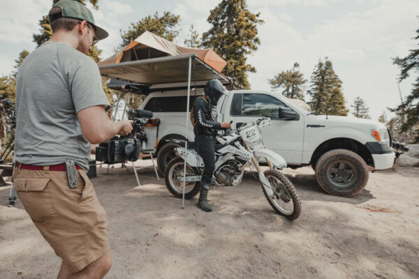 Filmmaker with dirt bike rider in front of truck