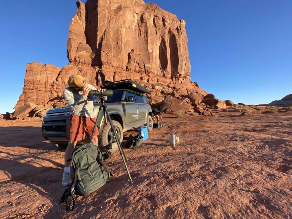 Overlander using a spotting scope in the desert.