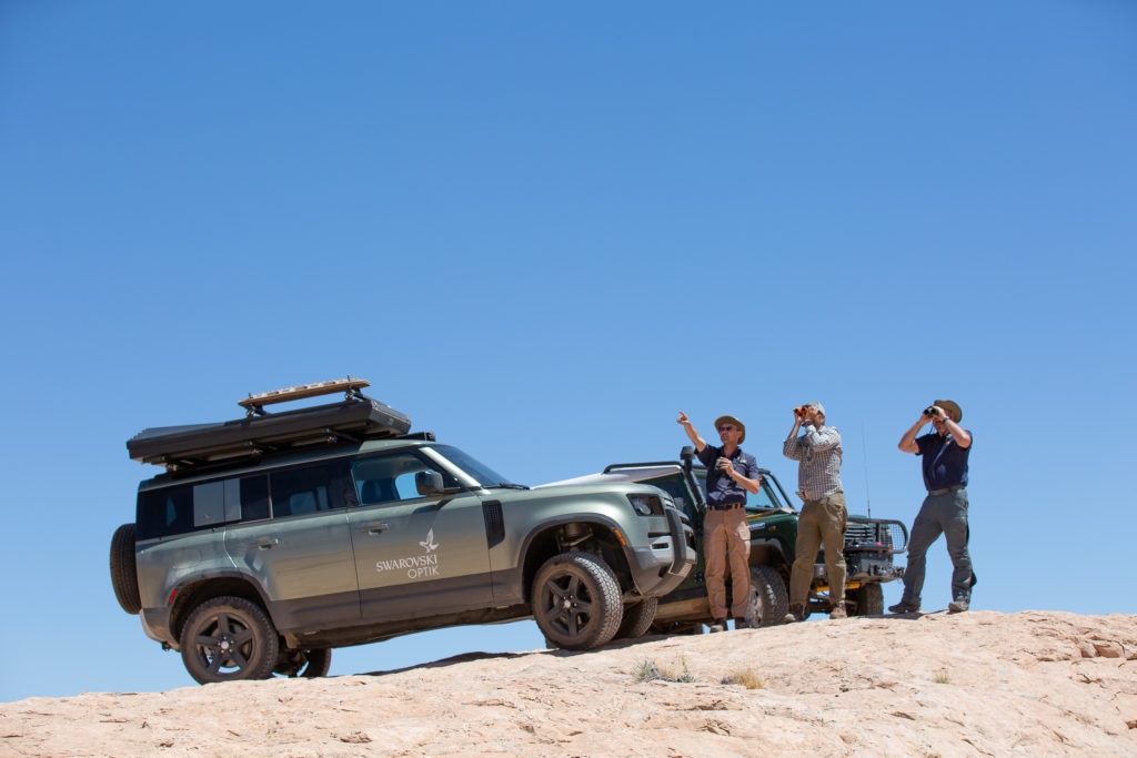 Land Rover Defender and overlanders overlooking the desert.