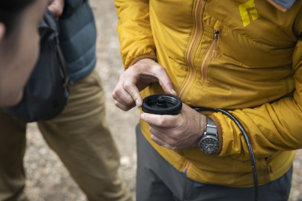 Close up of hikers inspecting a water filter.