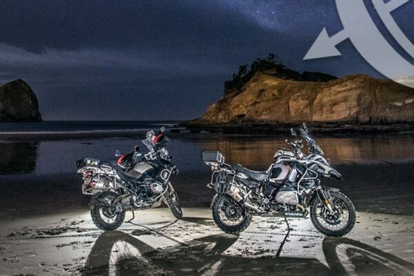 BMW motorcycles parked on a beach at night