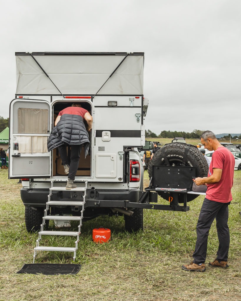 Man and woman getting into their truck camper.