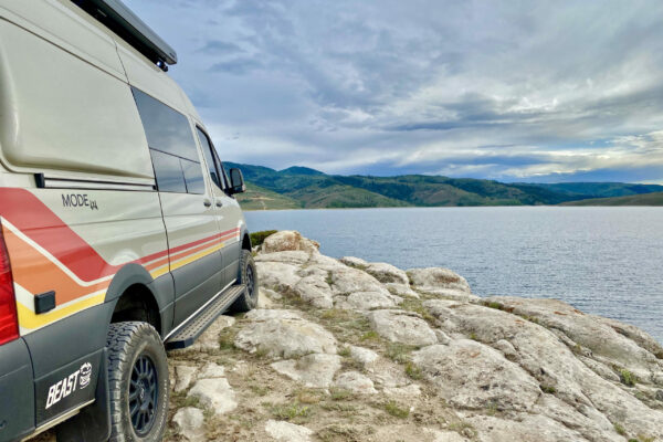 Beast MODE Adventure Van by Storyteller Overland near a lake in Utah.