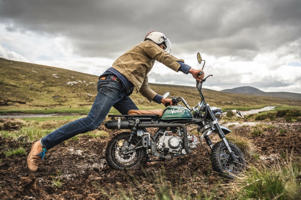 Man with Venturo mini-motorcycle in the mud