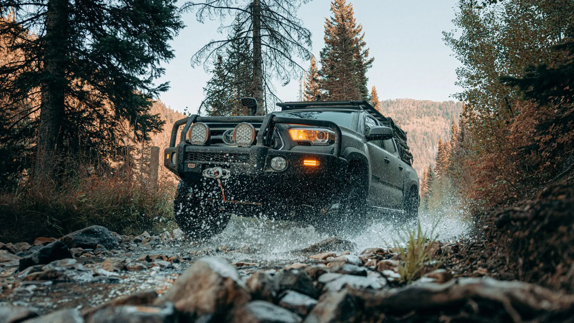 Toyota Tacoma in a water crossing in the backcountry.