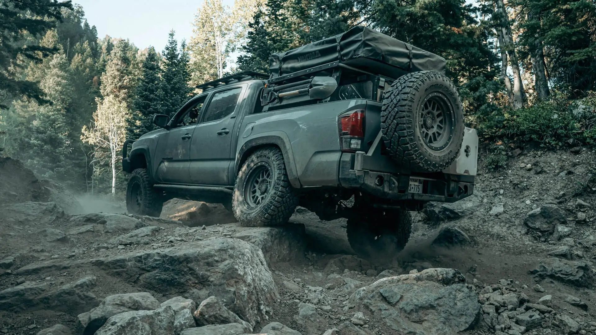 Toyota Tacoma navigating a boulder field on a backcountry trail