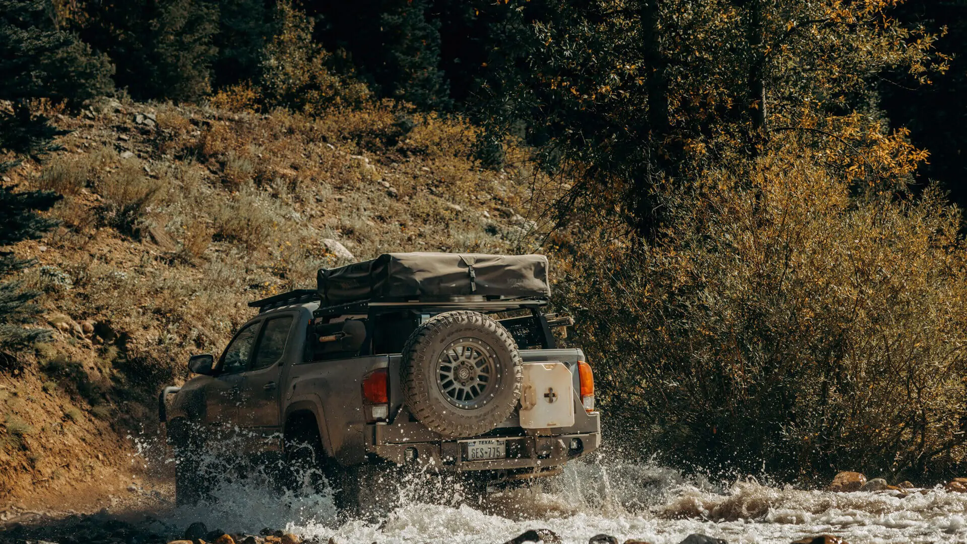 Toyota Tacoma in a water crossing in the backcountry.