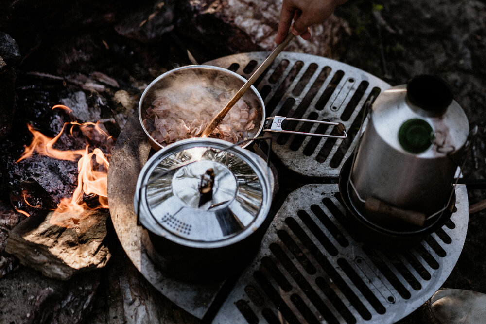 Food cooking over and open fire on Front Runner Outfitters' Spare Tire Mounted Braai.