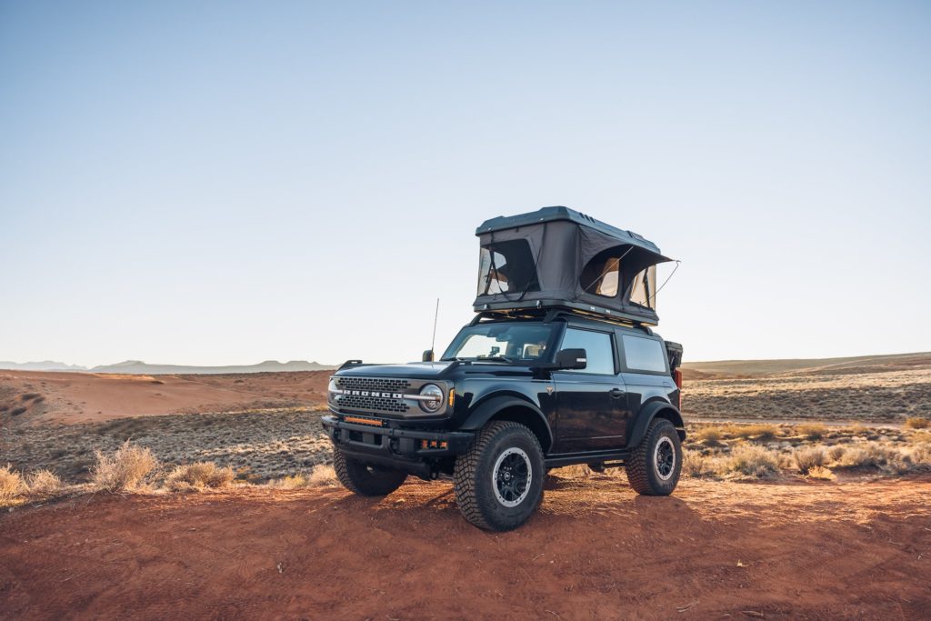 The Roam Rambler Hardshell Rooftop Tent deployed on a Ford Bronco in the desert.