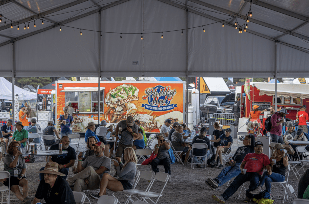 People enjoying the Oasis food and beverage area at Overland Expo WEST