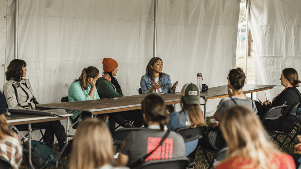 People listening to a guest speaker on a panel in the Roundtable Pavilion at Overland Expo.