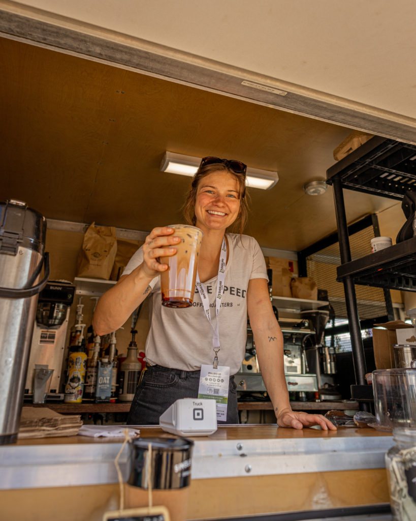 Woman serves coffee at overland expo west