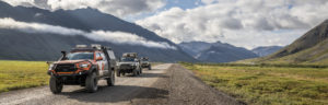 XOverland vehicles on a dirt road in Alaska