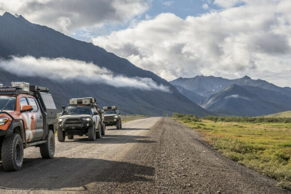 XOverland vehicles on a dirt road in Alaska