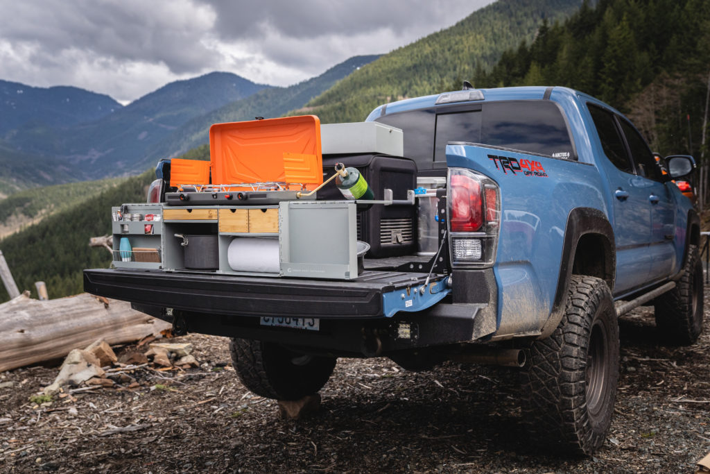 Green Goat Outdoors Camp Kitchen open on the tailgate of a truck.