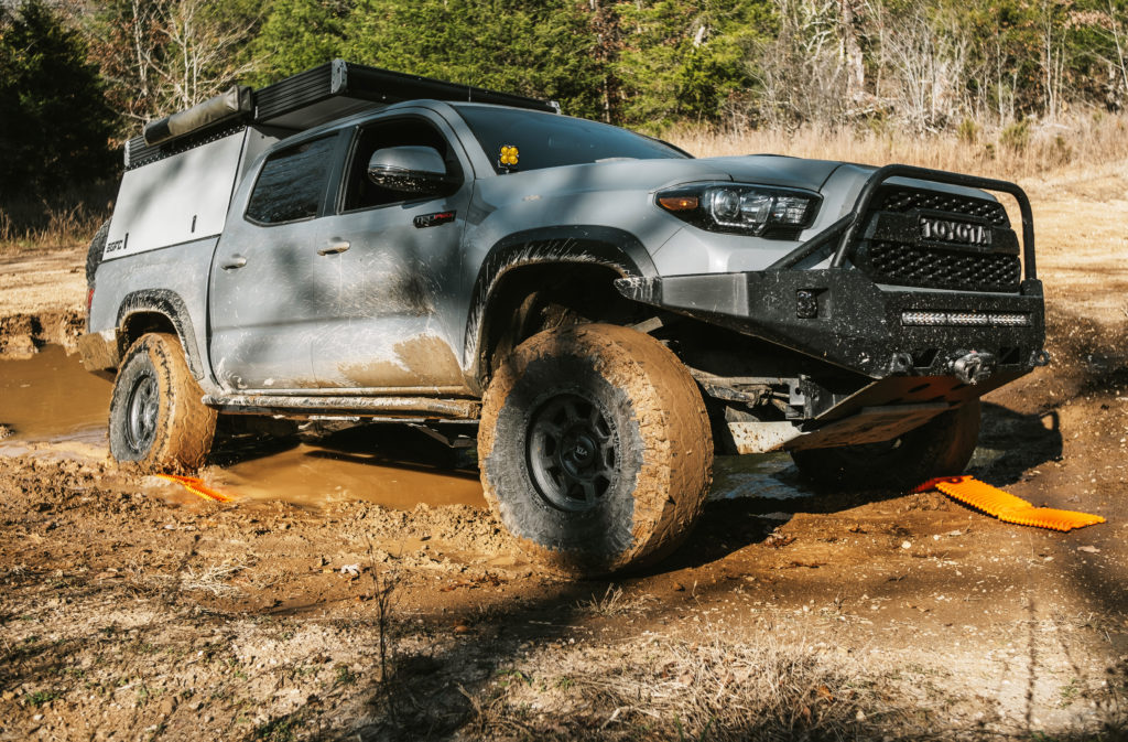 Using a set of GoTreads traction boards to recover a Toyota Tacoma from a muddy portion of a trail.