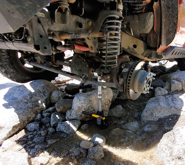 A Jeep lifted to repair a tire using a Safe Jack General bottle jack