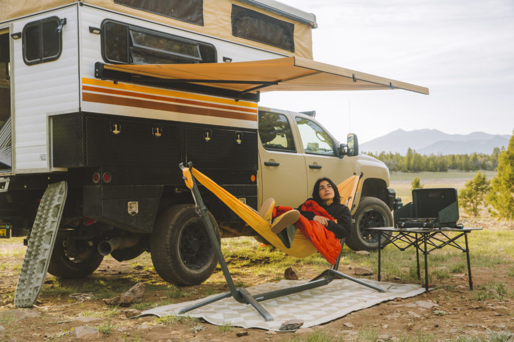 Woman sitting in a hammock under the Kammok Crosswing.