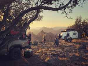 Camper trailer and people near a canyon.