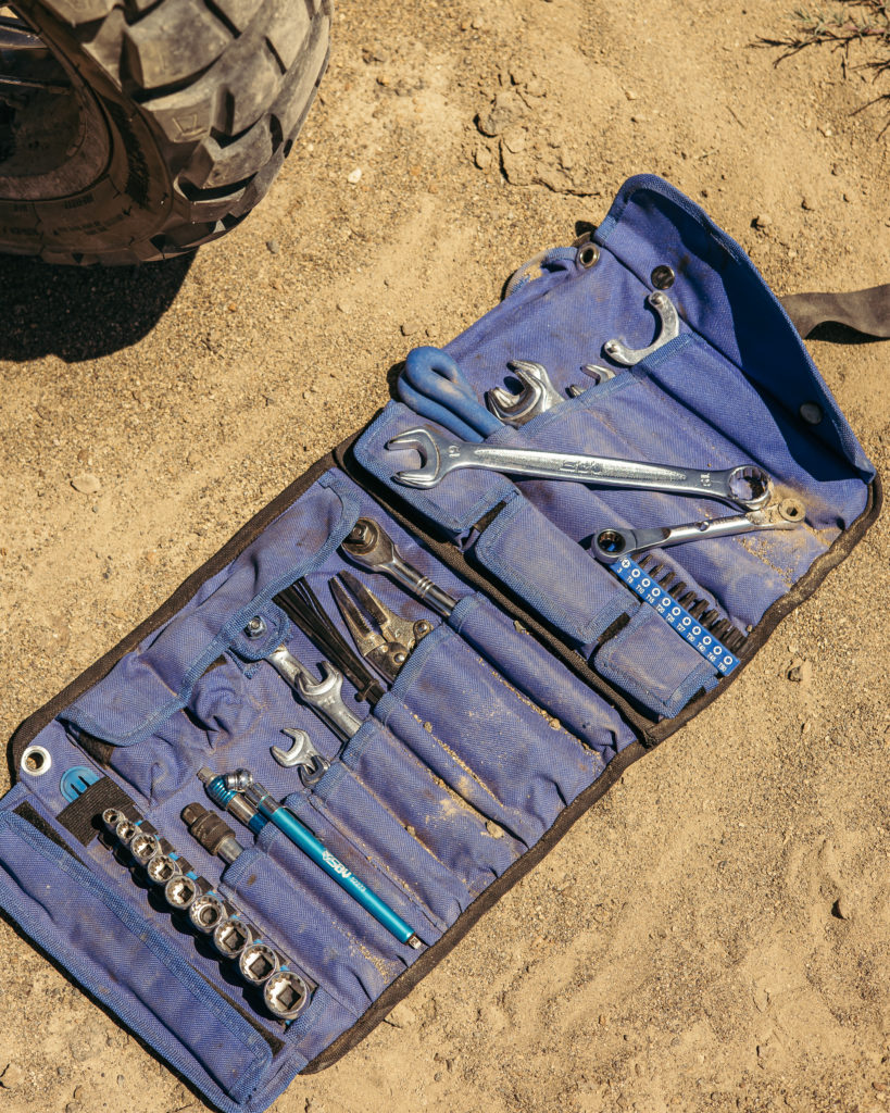 Tool roll opened up in the desert with tools.