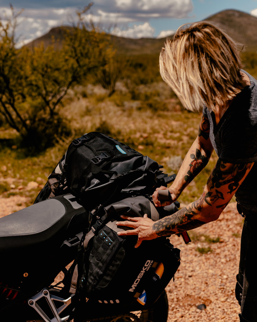 Woman packing soft panniers on motorcycle.