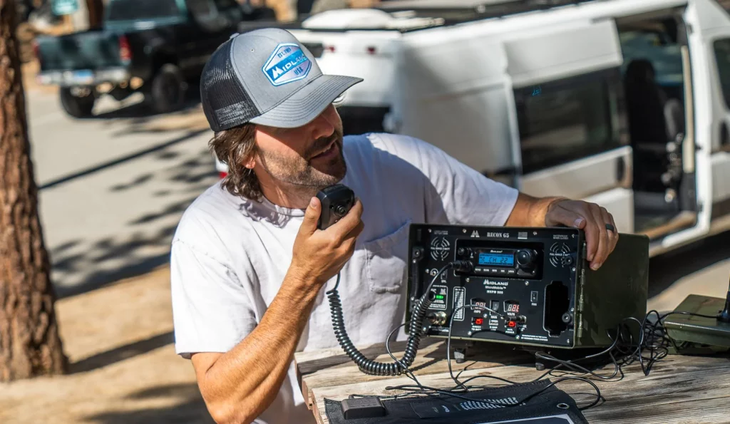 Man using the Midland Radio Base Station in the backcountry.