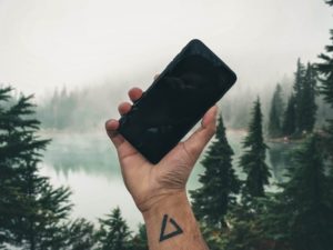 holding up iphone in wilderness