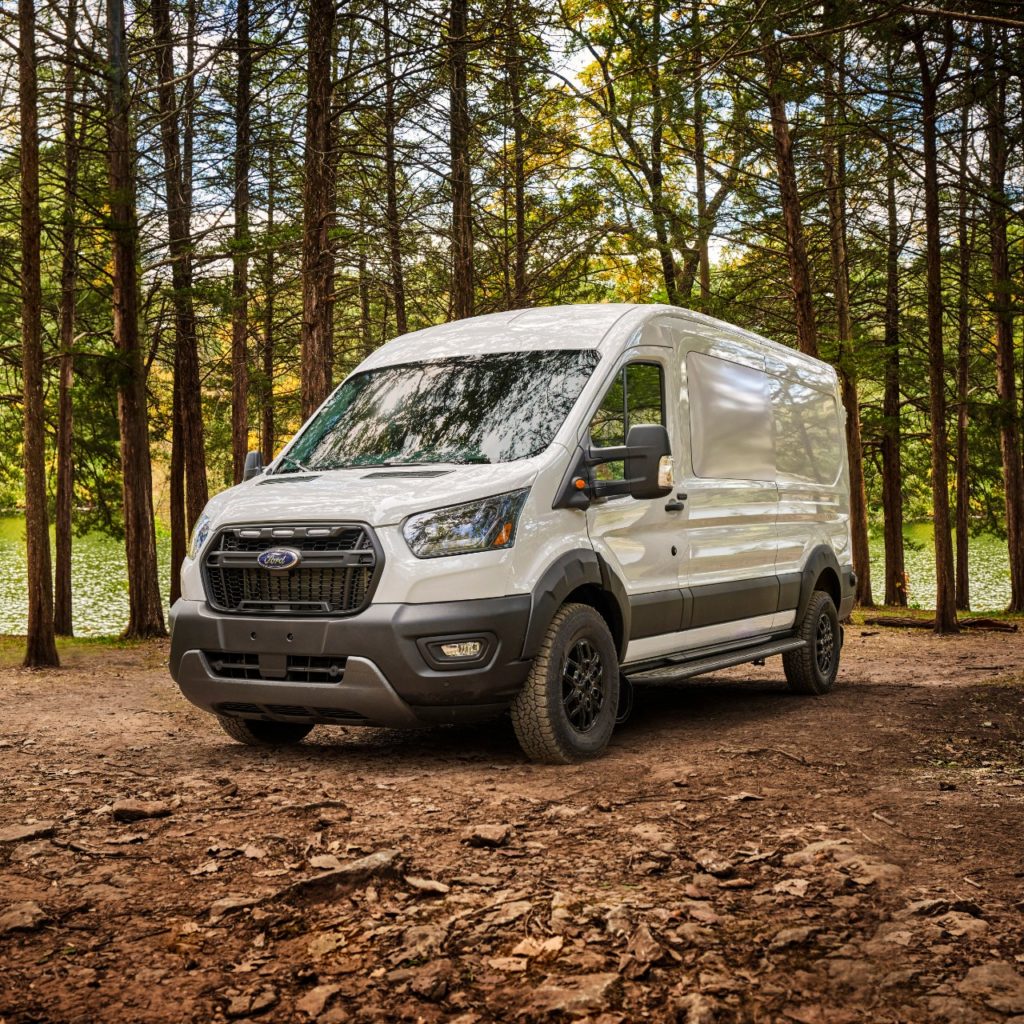 Ford Transit Trail parked in the woods.