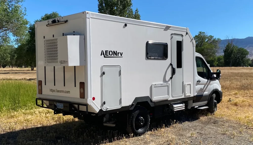 Rear 3/4 view of the AEONrv off the grid in a forest.