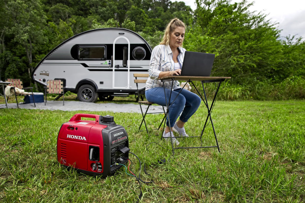 A woman powering her off grid office with Honda's EU2200i 2200/1800 Watts Inverter Generator.