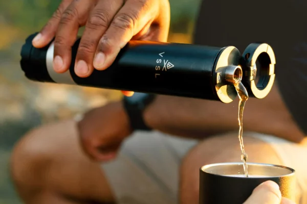 Man pouring a drink from the VSSL Insulated Flask with Bluetooth Speaker